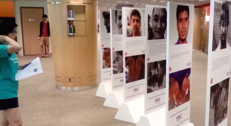 Photo: A student viewing the migrant worker exhibition at the National University of Singapore (NUS), NUS Libraries | Credit: Kalinga Seneviratne