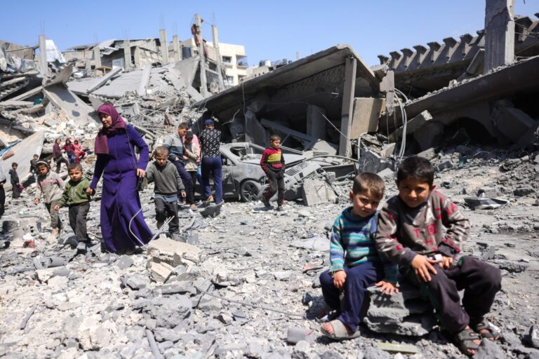 TOPSHOT - Children look on as people walk amid the rubble of a building destroyed in an overnight Israeli strike in Jabalia, in the northern Gaza Strip on March 18, 2025. Israel's deadly strikes on Gaza drew global condemnation on March 18, as it said it had "no alternative" other than to resume military operations in order to bring home hostages. (Photo by Bashar TALEB / AFP) (Photo by BASHAR TALEB/AFP via Getty Images)