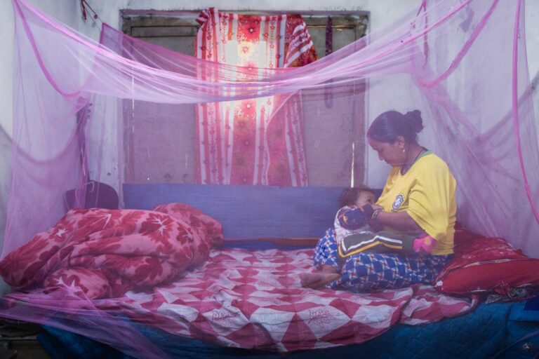 Devi Kanya Kathayat, 33, breastfeeds her son Nehan Budha, 2, under a mosquito net in their home in Chandannath, Jumla, 2,438m. He family lives at 2,438m but now need mosquito nets to prevent infection. https://nepalitimes.com/mosquitos-ascend-to-the-base-of-mt-everest