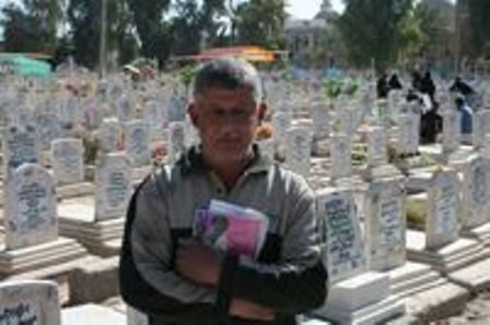 Cemetery manager Abu Ayad Nasir Walid with his logbook of the dead. Credit: Dahr Jamail.