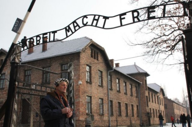 Igor Malitski in front of the gate to Auschwitz. Credit: Christian Papesch/IPS