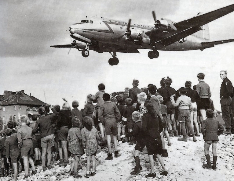 Photo: Citizens of Berlin watch a C-54 land at Berlin Tempelhof Airport in 1948 (US Air Force via Wikimedia Commons)