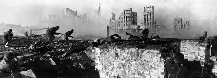 Photo: Soviet soldiers attack, February 1943. The ruined Railwaymen's Building is in the background. CC BY-SA 3.0