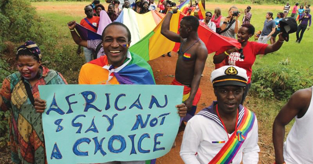 Photo: A group of pro-gay marchers in Ghana, dressed in bright clothing holding signs and rainbow flags. Source: GCN.