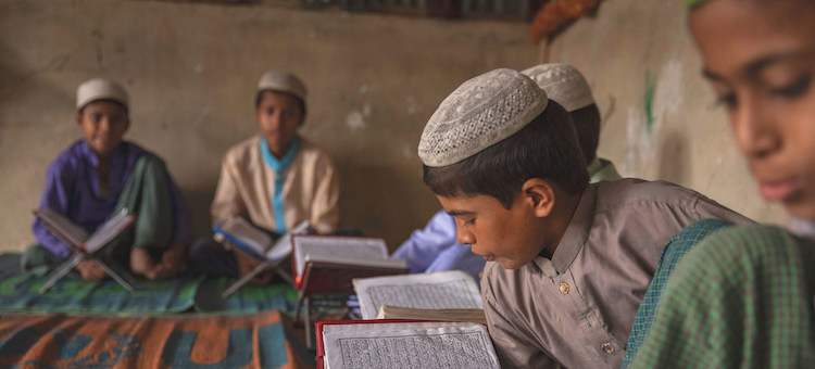Photo: A boy reads from his textbook in a camp in Cox's Bazar, Bangladesh. Credit: UNICEF Patrick Brown