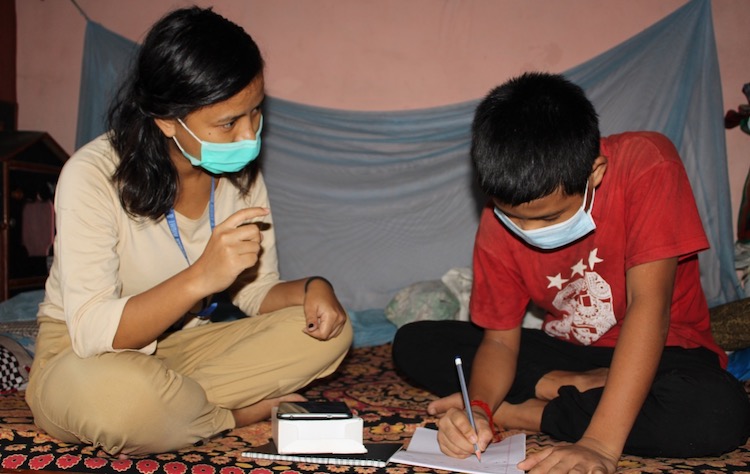 Photo: Young Abishek, who has hearing impairment, studies with a Reading for All project’s learning facilitator at his home using a Nepali sign language learning app called “Mero Sanket”. Credit: Humanity & Inclusion