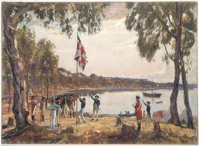 The Founding of Australia” by Captain Arthur Phillip RN Sydney Cove, 26 January 1788, faithful photographic reproduction of 1937 Oil Painting by Algernon Talmage, picture from Wikimedia Commons, license: public domain