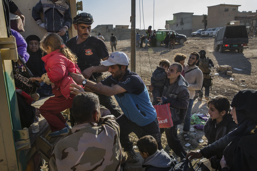 Families flee their homes in Mosul, Iraq, heading for an army outpost in the Samah neighbourhood where they will be taken away from the heavy fighting engulfing the city. Photo: UNHCR/Ivor Prickett