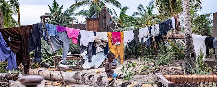 Photo: A boy sits amid scenes of destruction in Macomia town after it was hit by tropical cyclone Kenneth, which made landfall in Cabo Delgado province in Northern Mozambique, on 25th April 2019. Credit: Tommy Trenchard/Oxfam