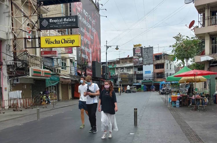 Photo: Handful of tourists in a deserted Khaosan which was before the pandemic filled with street stalls and tourists. Credit: Pattama Vilailert.