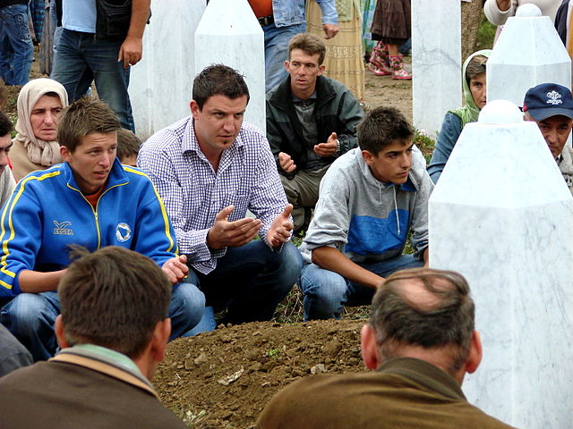 Male mourners at the reburial ceremony for an exhumed victim of the Srebrenica Massacre. Potocari, Bosnia and Herzegovina. July 11, 2007. / By Adam Jones Adam63 - Own work, CC BY-SA 3.0