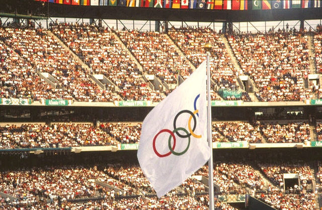 1996 Atlanta Olympics--Olympic flag at track and field venue. Olympic Stadium. Crowd scene./  Content Providers(s): CDC/Dr. Edwin P. Ewing, Jr., Public Domain